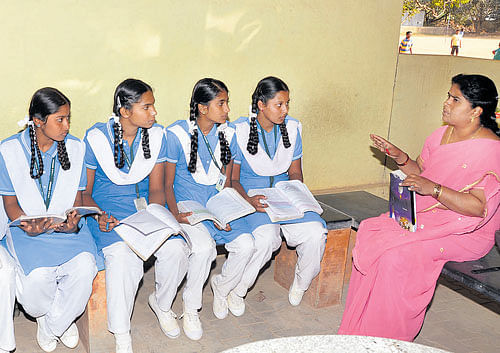 A teacher clears doubts of students in a study group at KK&#8200;English High School on Varthur Road in the City. DH&#8200;PHOTO