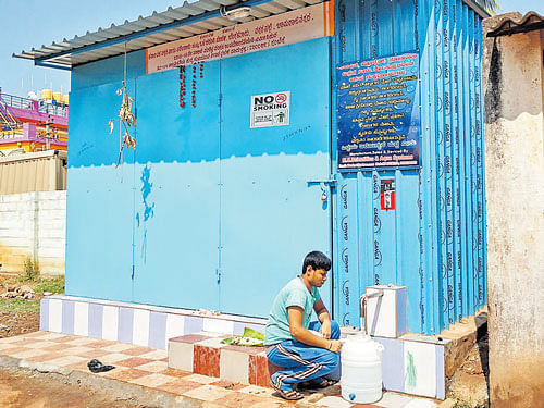 A man collects drinking water from a water purification and distribution unit in Bhramarambha Layout, Chamarajanagar. DH photo