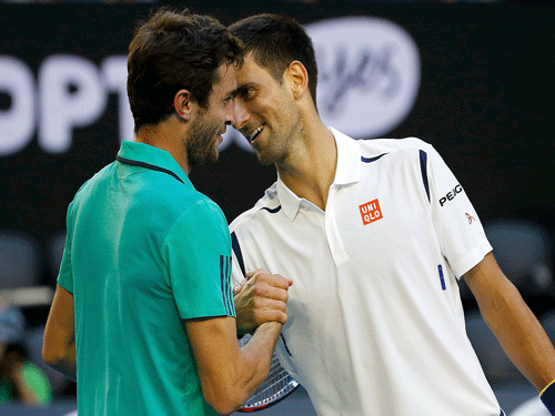 Serbia's Djokovic and France's Simon laugh as they shake hands at the net after Djokovic won their fourth round match at the Australian Open tennis tournament at Melbourne Park. Reuters Photo.