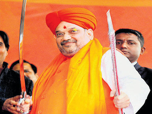 Amit Shah holds swords in New Delhi on Sunday. PTI