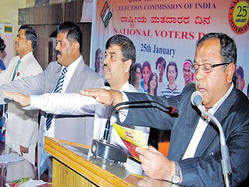 Deputy Commissioner Meer Anees Ahmed administers an oath to voters on National  Voters' Day at Old Fort Hall in Madikeri on Monday. DH photo