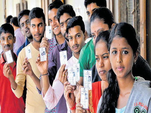 First-time voters display their photo identity cards during  National Voters Day at Town Hall, on Monday. Dh photo