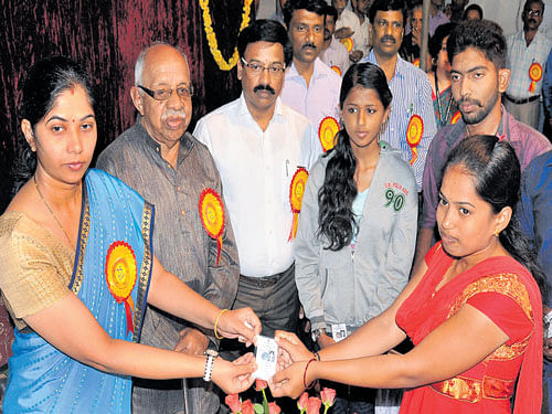 Deputy Commissioner C&#8200;Shikha distributes EPICs&#8200;to students, who were newly enrolled as voters, during the National Voters Day organised by district administration and Mysuru City Corporation at Town Hall in Mysuru, on Monday. DH photo