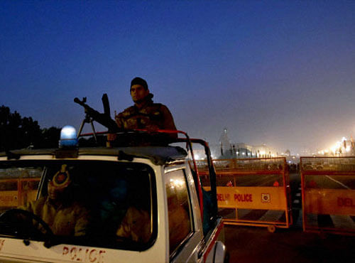 A security person keeps vigil at Rajpath on the eve of Republic Day parade in New Delhi on Monday. PTI Photo
