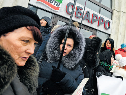 fed up: Workers at a Sbarro restaurant, who claim they have not been paid for three months, protest in Moscow. Illegal protests and wildcat strikes are erupting from all sorts of Russians who are now facing steep government cutbacks due to plummeting revenue from oil. nyt