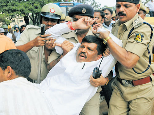 Police detain former minister Goolihatti Shekar, who is leading the protest by '108' staffers, in Bengaluru on Wednesday. DH&#8200;PHOTO