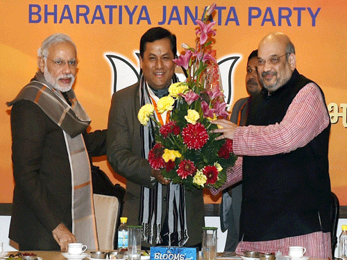 Prime Minister Narendra Modi and BJP President Amit Shah greet party leader Sarbananda Sonowal after he was named as Assam Chief Ministerial candidate at the party's parliamentary board meeting in New Delhi on Thursday. PTI Photo.
