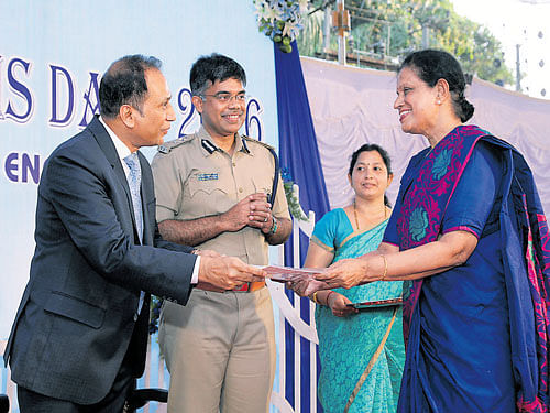 Central Excise and Service Tax Commissioner of Customs Dr M Subramanyam hands over commendation certificate to Advocate Asha Nayak during the Customs Day celebrations in Mangaluru. City Police Commissioner Chandra Sekhar looks on. DH&#8200;photo