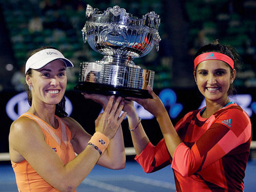 Martina Hingis, left, of Switzerland and Sania Mirza of India hold their trophy aloft after defeating Czech Republic's Andrea Hlavackova and Lucie Hradecka in the women's doubles final at the Australian Open tennis championships in Melbourne, Reuters photo