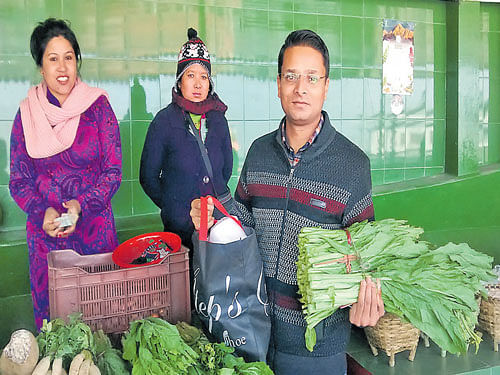 Maya Pradhan (left) of the Manjoshree Self Help Group of Jaubari village sells vegetables at Organic Market in Gangtok. Roshan Sujee, who runs a printing business in Gangtok, with fresh vegetables. Sagar Kulkarni