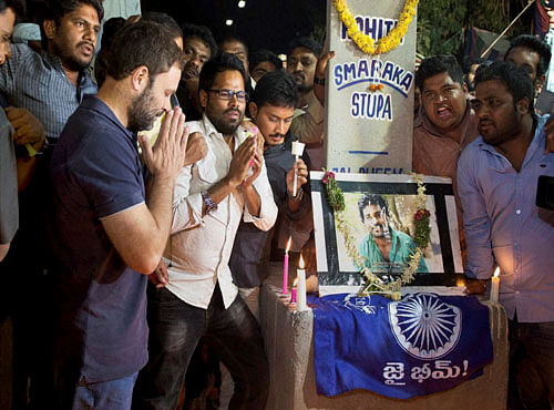 Congress Vice President Rahul Gandhi lights a candle near a memorial of Rohith Vemula to pay him tributes during a visit to University of Hyderabad where the students are agitating, in Hyderabad on Friday night. PTI Photo