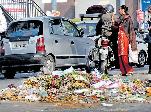 STINKING CRISIS: Garbage is strewn around Vikas Marg as the workers of Municipal Corporation of East Delhi have continued their protest over non-payment of salaries, in East Delhi on Saturday. DH PHOTO
