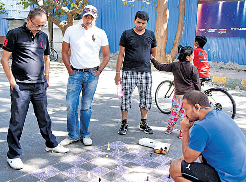 Residents play a gameof chess as part of the 'open street cycle day' on Jeevaraj Alva Road on Sunday. DH PHOTO