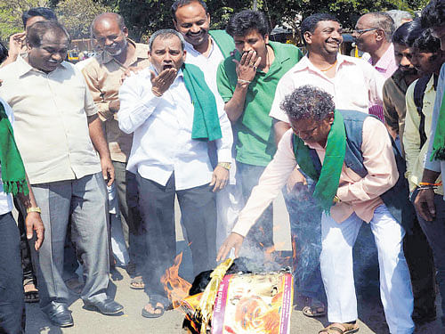 Farmers set fire to a poster of Prime Minister Narendra Modi, during a protest against the Union government over the  Mahadayi water dispute, in Dharwad on Sunday. dh photo