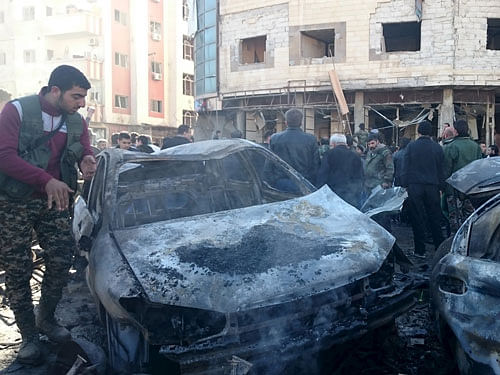 Residents and soldiers loyal to Syria's President Bashar al-Assad inspect damage after a suicide attack in Sayeda Zeinab, a district of southern Damascus. Reuters