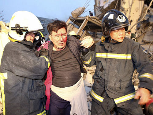 Rescue personnel help a victim at a damaged building after an earthquake in Tainan. Reuters photo