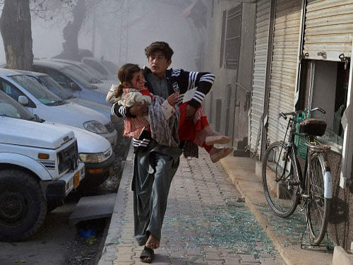 An injured boy carries an injured girl as he runs towards a safe area a few minutes after a suicide bombing in Quetta, Pakistan. At least eight people, including two security personnel, were killed and 25 others injured today when a powerful blast targeted a Frontier Corps convoy. PTI photo