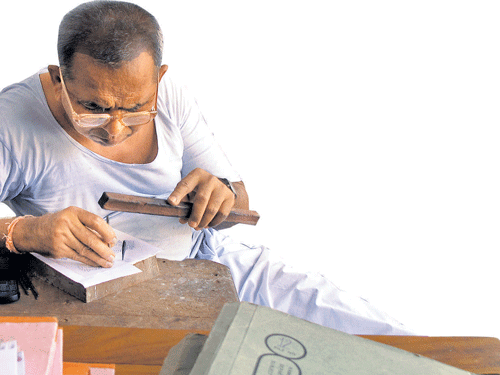 block by block : Artist Govindlal Prajapati carves a wooden block in his studio.