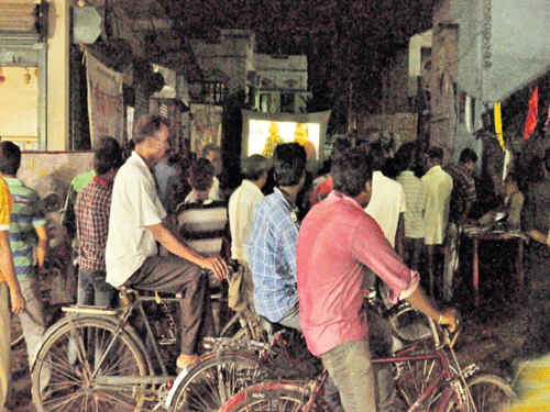 People watch a film at an outdoor screening at Halishar town in West Bengal.