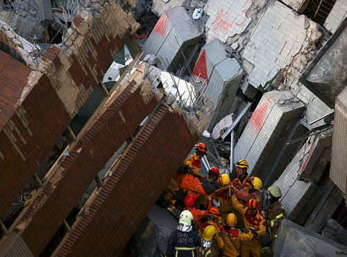 Rescuers carry a survivor out from the site where a 17-storey apartment building collapsed after an earthquake hit Tainan. Reuters photo