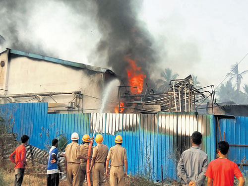 Fire fighters douse a fire at an Ayurvedic medicine manufacturing unit at Mallarabanawadi village near Nelamangala in Bengaluru Rural district on Monday afternoon. DH PHOTO