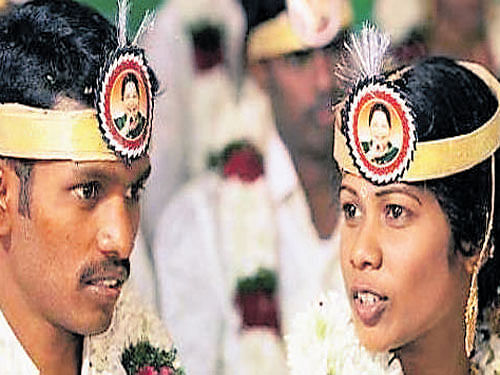 A newlywed couple wears headbands with the image of  Jayalalitha at a mass marriage ceremony in Tamil Nadu.