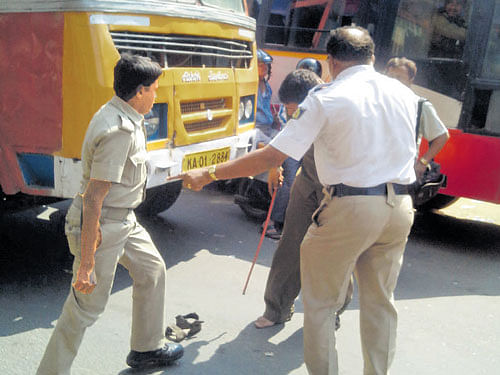 A Home Guard is assaulted by a KSRTC driver at Jalahalli Cross in the City on Tuesday afternoon. dh photo
