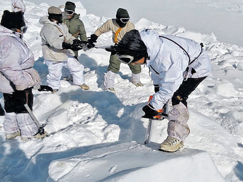 A soldier cuts through ice and snow in search for survivors on the Siachen glacier. Lance Naik Hanmanthappa (inset) who was found alive. AFP