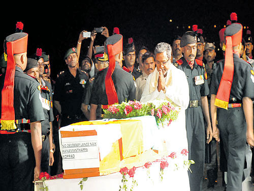 Chief Minister Siddaramaiah pays his last respects to Lance Naik Hanmanthappa Koppad at the Hubballi Airport on Thursday. DH photo