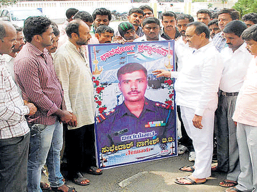 Tejuru villagers protest in Hassan on Friday, demanding information on the steps taken by the authorities to bring the body of soldier T T Nagesh.