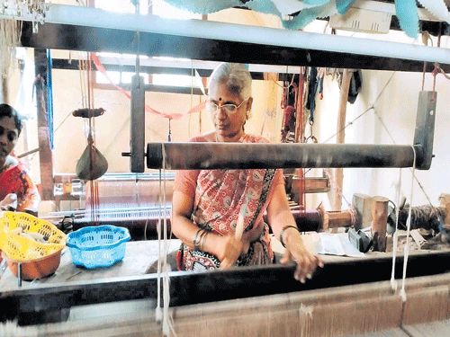 A woman weaves a cotton mixed saree, which is dyed with natural colours and immersed in herbal paste.