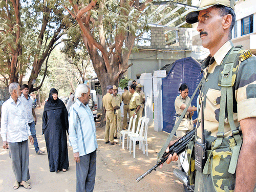 Border Security Force personnel guard a polling station at the Presidency School in RT Nagar of Hebbal Assembly  constituency in Bengaluru on Saturday. DH Photo