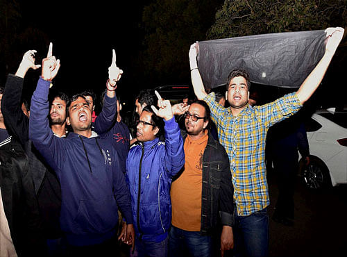 Students show black flags to Congress Vice president Rahul Gandhi (unseen) at the Jawaharlal Nehru University (JNU) in New Delhi on Saturday. Rahul Gandhi and many left leaders went to the campus to meet the students protesting for the release of Student Union president Kanhaiya Kumar. PTI Photo