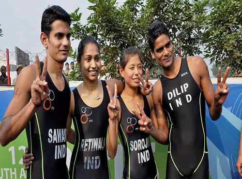 From left Dhiraj Sawat, Pallavi Retiwala, Sorojini Devi Thoudam and Dilip Kumar of India pose for photos after winning gold in team event Triathlon race at the 12th South Asian Games in Guwahati on Sunday. PTI Photo