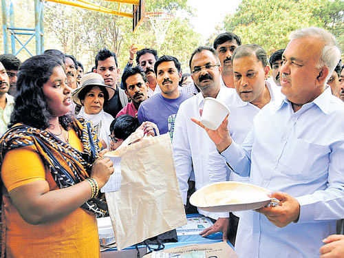 Minister Ramalinga Reddy distributes alternatives to replace plastic containers as part of a campaign undertaken by the BBMP at Koramangala on Sunday. KPN