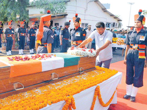 tributes: Minister Satish Jarkiholi pays his last respects to soldier Sahadev More at the  Sambra airport in Belagavi on Sunday. dh Photo