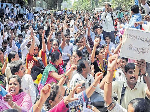 Guest lecturers from across the State stage a protest in Bengaluru on Monday, opposing the government's move to conduct a fresh recruitment to replace them. dh photo