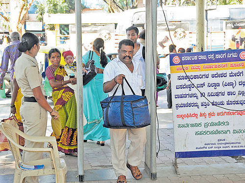 Passengers pass through the metal detector as part of  security measures at the Kempegowda Bus Station in  Majestic. DH FILE PHOTO