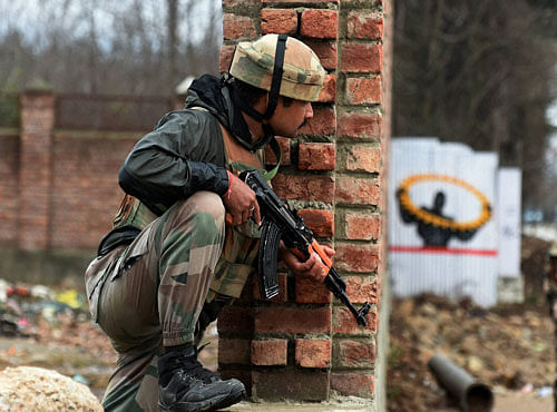 A security forces personnel takes position outside the JKEDI building where militants have reportedly taken refuge afer launching an attack on a CRPF convoy at Sampora Pampore near Srinagar on Saturday. PTI Photo