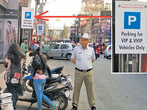 Traffic police are clueless about this boardwhich reserves parking space for the privileged class on Brigade Road. DH PHOTO