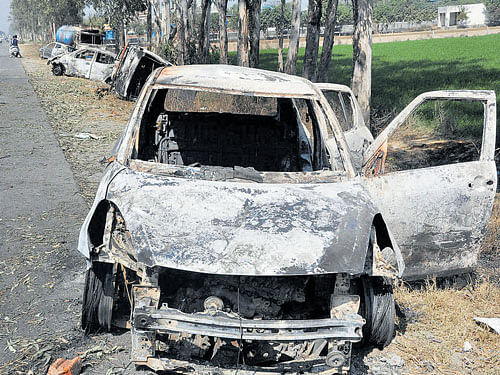 Vehicles which were set on fire by Jat protesters demanding reservation, at GT Road near Sonipat on Tuesday. PTI