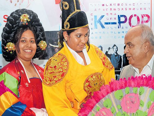 Prof B Thimme Gowda, Vice Chancellor of Bangalore University, with students dressed in  traditional South Korean attire at the International Language Fair at the Jnanajyothi  Auditorium on Sunday. DH PHOTO