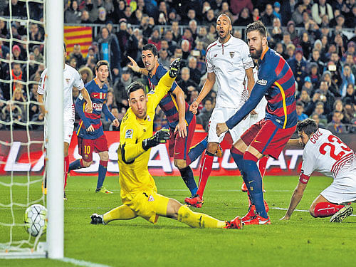 cheeky: Gerard Pique (right) of Barcelona scores past Sevilla's goalkeeper Sergio Rico during their La Liga tie. reuters