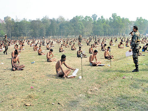 Trust issues: Candidates for the army sit in their underwear in a field as they take a written exam after being asked to remove their clothing to deter them from cheating during a recruitment day in Muzaffarpur on Sunday. AFP
