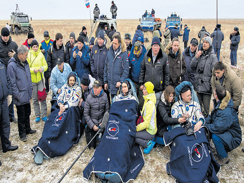 American astronaut Scott Kelly (right) and Russian cosmonauts Sergei Volkov (centre) and Mikhail Korniyenko, surrounded by ground personnel, rest shortly after landing near the town of Dzhezkazgan, Kazakhstan, on Wednesday. REUTERS