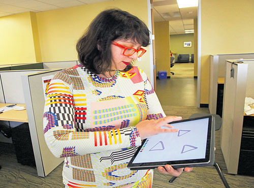 Jennifer Daniel, a graphic designer forThe NewYork Times, with an iPad Pro. Designers like Daniel say despite the new device, they still had to turn to a computer formore powerful apps. INYT