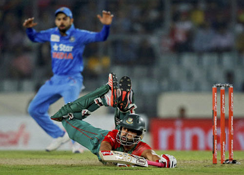 Bangladesh's Tamim Iqbal, on ground, drives to make his ground during the Asia Cup Twenty20 international cricket final match against India in Dhaka.. AP/PTI