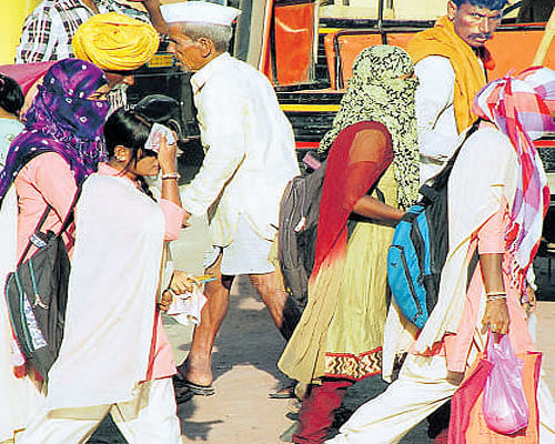 Women walk, covered from head to toe, due to  severe heat in Vijayapura on Monday. DH Photo