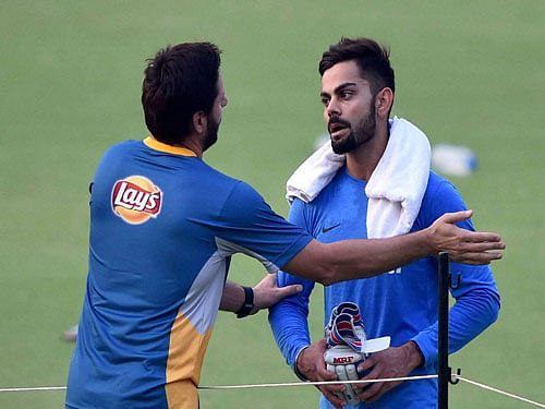 Pakistan's captain Shahid Afridi interacts with Virat Kohli during their training session at the Eden Gardens in Kolkata on Friday prior to their ICC T20 World cup match. PTI Photo.
