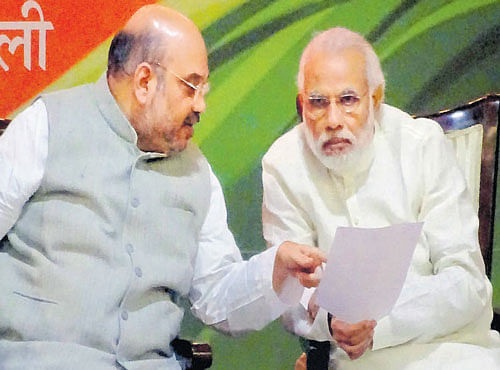 Prime Minister Narendra Modi (R) and BJP President Amit Shah in conversation during BJP's national executive meeting in NewDelhi on Sunday. PTI